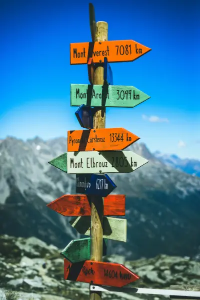 Colourful signs silhouetted against mountains and a blue sky