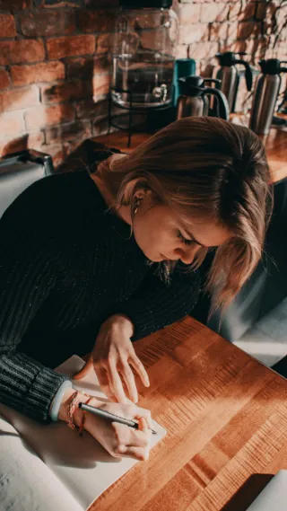 Training sidebar v1 Woman writing in notebook